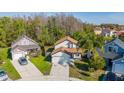 An aerial view of a two-story home with a manicured lawn and driveway amidst lush greenery and neighboring houses at 2405 Cancun Ct, Kissimmee, FL 34743