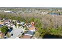 An aerial shot of a home located in a peaceful neighborhood, surrounded by lush trees and scenic views of a tranquil lake at 2405 Cancun Ct, Kissimmee, FL 34743