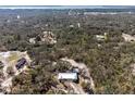 Expansive aerial shot of the home nestled within a lush, wooded landscape, offering privacy and a serene setting at 2466 R E Byrd Rd, Frostproof, FL 33843