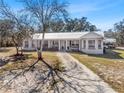 Attractive home with a metal roof and a welcoming front porch, complemented by well-maintained landscaping at 2466 R E Byrd Rd, Frostproof, FL 33843