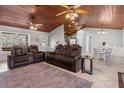 Inviting living area with a vaulted wood ceiling, neutral tile flooring, and comfortable leather seating at 2466 R E Byrd Rd, Frostproof, FL 33843