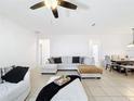 Spacious living room featuring neutral walls, tile flooring, and a comfortable sectional sofa at 249 Hamlet Loop, Davenport, FL 33837