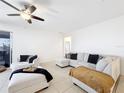 Bright living room featuring neutral walls, tile flooring, and comfortable white sectional sofa at 249 Hamlet Loop, Davenport, FL 33837