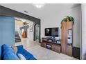 Comfortable living room featuring tile floors, a sofa, a large entertainment system and staircase access at 2933 White Cedar Cir, Kissimmee, FL 34741