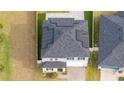 Overhead view of the house showing solar panels on roof with lush green lawn and driveway at 2984 Sanctuary Dr, Clermont, FL 34714