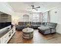 Spacious living area featuring a gray sectional sofa, ceiling fan, and a decorative center table at 3403 Greenwich Village Blvd # 104, Orlando, FL 32835