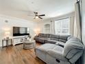 Comfortable living room with a large sectional sofa, modern ceiling fan, and bright natural light at 3403 Greenwich Village Blvd # 104, Orlando, FL 32835