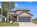 Inviting two-story home with a large garage, mature landscaping, and a well-maintained front lawn at 3509 S Saint Lucie Dr, Casselberry, FL 32707