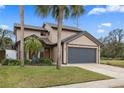 Inviting two-story home with a large garage, mature landscaping, and a well-maintained front lawn at 3509 S Saint Lucie Dr, Casselberry, FL 32707