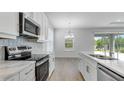 Bright kitchen with stainless steel appliances, white cabinets, quartz countertops, and stylish backsplash, great for cooking and entertaining at 4198 Barbuda Ln, Kissimmee, FL 34758