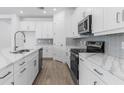 Modern kitchen featuring white cabinetry, stainless steel appliances, quartz countertops, and a stylish backsplash for a contemporary feel at 4198 Barbuda Ln, Kissimmee, FL 34758