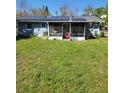 Backyard view with screened porch and green grass at 4202 Mizell St, Orlando, FL 32812