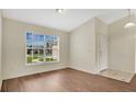 Bright living room features sleek wood floors and a large window overlooking a beautifully landscaped yard at 5071 Heatherstone Dr, Kissimmee, FL 34758