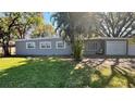 This single-story home has three windows, a one-car garage, and a well maintained yard with mature trees and landscaping at 5200 Brosche Rd, Orlando, FL 32807