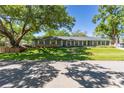 Attractive single-story home with gray siding, white shutters, and a well-maintained lawn and mature trees at 7614 Lake Dr, Belle Isle, FL 32809