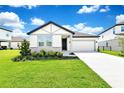 Well-maintained single-story home with a two-car garage, lush lawn, and attractive landscaping at 780 Livestock Loop, St Cloud, FL 34771