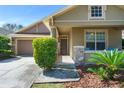 Inviting covered front porch with stone accents, lush plants, and seating area for relaxing at 12824 Penshurst Ln, Windermere, FL 34786