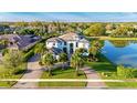 Beautifully landscaped luxury home with a circular driveway, tile roof and lush tropical foliage, located near a picturesque lake at 13305 Bellaria Cir, Windermere, FL 34786