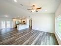 Open-concept living room with hardwood floors, natural light, and modern ceiling fan at 14 Locust Radial Way, Ocala, FL 34472