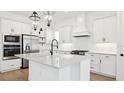 Well-equipped kitchen with stainless appliances, white cabinets, a center island, and stylish pendant lights at 15543 Gentle Rain Dr # 197, Winter Garden, FL 34787