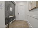 Elegant foyer with decorative mirror, console table, and stylish wall paneling at 15567 Gentle Rain Dr # 194, Winter Garden, FL 34787