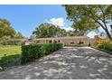 View of the home's driveway, lush green lawn, and manicured hedges at 215 Forrest Dr, Sanford, FL 32773