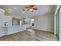 Open-concept kitchen and living room with modern white cabinets and wood-look floors at 2156 Fish Eagle St, Clermont, FL 34714