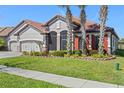 Beautiful home with three-car garage, red shutters, tile roof, and manicured landscaping at 2541 Shoal Bass Way, Kissimmee, FL 34746