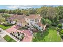 Stunning aerial view of a two-story home showcasing the tile roof, long driveway, and mature trees at 2747 Kissimmee Bay Cir, Kissimmee, FL 34744