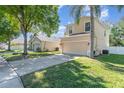 Charming home with a two-car garage, complimented by a lush lawn and mature shade trees on a sunny day at 322 Lusitano Way, Sanford, FL 32773