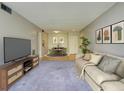 Inviting living room boasts soft carpeting, a comfortable sofa, and a view into the dining area at 3242 S Semoran Blvd # 21, Orlando, FL 32822