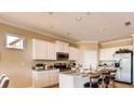 Bright eat-in kitchen with granite counters, stainless appliances, white cabinetry and seating at island at 3965 Kennebunk Loop, Mount Dora, FL 32757