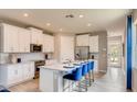 Modern kitchen with stainless steel appliances, white cabinets, granite countertops and bar seating at 3971 Kennebunk Loop, Mount Dora, FL 32757