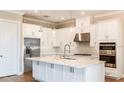 Bright kitchen featuring stainless steel appliances, white cabinets, and a center island at 4197 Barbuda Ln, Kissimmee, FL 34758