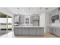 Open kitchen featuring gray cabinets, a large kitchen island, and a view of the backyard at 4203 Barbuda Ln, Kissimmee, FL 34758