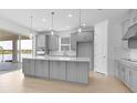 Bright kitchen with a spacious center island, stainless steel appliances, and sliding glass doors at 4203 Barbuda Ln, Kissimmee, FL 34758