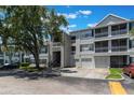 Exterior view of condos with garages, balconies, and a big shade tree in the front yard at 5144 City St # 238, Orlando, FL 32839