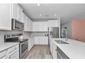 Modern kitchen featuring stainless steel appliances, white cabinets, and quartz countertops at 7699 Sw 74Th Loop, Ocala, FL 34481