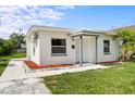 Inviting single-story home with a white exterior, gray trim, and vibrant green lawn at 859 Neuse Ave, Orlando, FL 32804