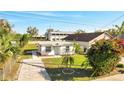 This cozy home features a well-maintained lawn, a vibrant bougainvillea, and a freshly paved driveway for added curb appeal at 859 Neuse Ave, Orlando, FL 32804