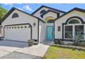 Close up of home's facade, light fixtures, blue front door, and well manicured lawn at 868 Shell Ln, Longwood, FL 32750