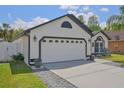Garage door and front facade of a single Gathering home with well manicured lawn at 868 Shell Ln, Longwood, FL 32750