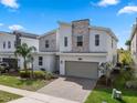 Contemporary home with stone details, a two-car garage, and a brick driveway, with landscaping at 8816 Cruden Bay Ct, Davenport, FL 33896