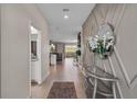 Inviting foyer with decorative wall trim, modern accents, and a view into the kitchen and living area at 8816 Cruden Bay Ct, Davenport, FL 33896
