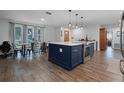 Open-concept kitchen with an island and wood-look floors at 9235 Everwood St, Orlando, FL 32825