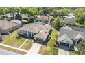 Expansive aerial view showcasing the home, landscaped yard, tile roof, and screened-in pool of a neighboring house at 442 Flora Creek Ct, Lake Mary, FL 32746