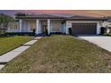Beautiful one-story home featuring manicured landscaping, a two-car garage, and a welcoming entrance at sunset at 442 Flora Creek Ct, Lake Mary, FL 32746