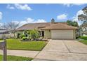 Inviting single-story home with a neatly landscaped front yard and attached two-car garage at 1002 Ohanlon Ct, Oviedo, FL 32765