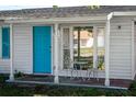 Close up of the front porch with a cozy seating area and a vibrant blue front door at 1315 Overdale St, Orlando, FL 32825