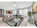 Bright living room with neutral decor, large sectional sofa, and view into dining and kitchen at 14318 Fieldstone Lake Way, Orlando, FL 32824